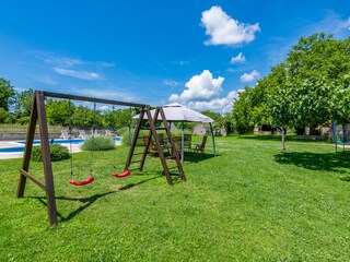 Geräumiger Garten mit einer Schaukel.