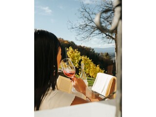 Sonne,  Wein und ein Buch auf der Terrasse genießen