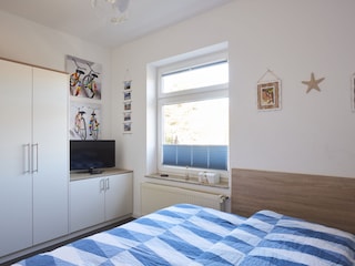 TV und Stauraum im kleineren Schlafzimmer