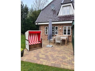 Terrasse mit Holzmöbeln und Strandkorb