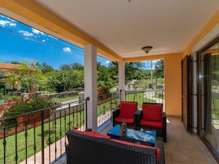 Ein Esstisch auf dem Balkon mit Blick auf den Garten