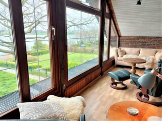 verglaster Balkon mit Sofa und Relaxliegen im DG