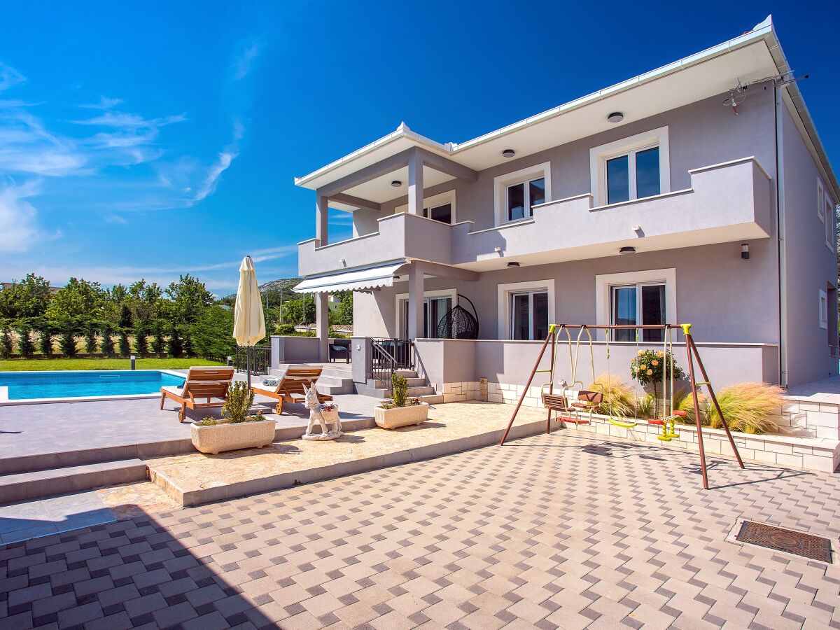 Überdachte Terrasse mit Essbereich neben dem Pool