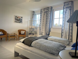 Schlafzimmer mit Doppelbett und auszieb. Schlafsessel