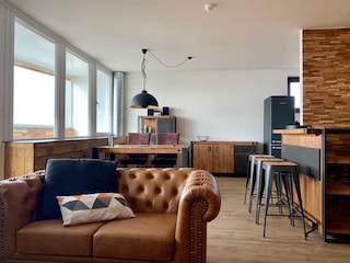 Wohnzimmer mit Esstisch und Bar