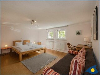 Schlafzimmer mit Doppelbett und separater Liege
