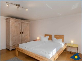 Schlafzimmer mit Doppelbett und separater Liege