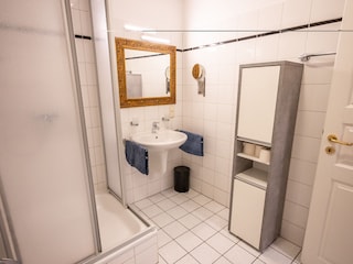 Badezimmer mit Dusche, Waschbecken, WC und Waschmaschin