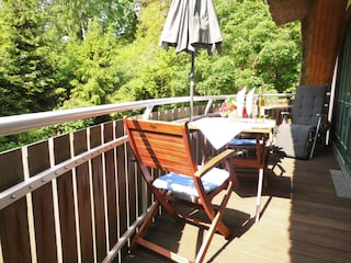 Balkon mit Tisch, Stühlen, Relaxliegen und Sonnenschirm