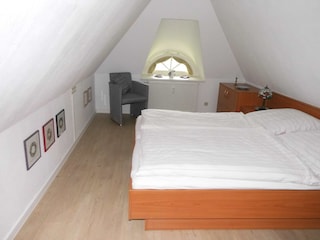 Schlafzimmer im Dachgeschoss mit Doppelbett und getrenn