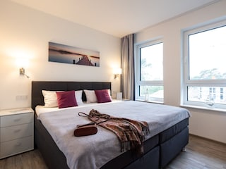 zweites Schlafzimmer mit bequemem Boxspringbett und TV