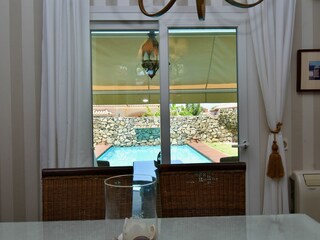 Blick vom Essbereich auf die Terrasse und den Pool