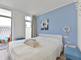 Schlafzimmer mit Doppelbett und angrenzender Terrasse