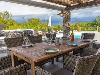 überdachte Terrasse mit Blick auf den Pool