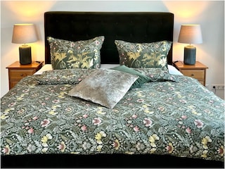 Schlafzimmer mit Boxspringbett und Balkonzugang