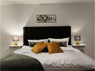 Schlafzimmer mit Boxspringbett und Balkonzugang