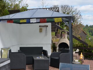 Pavillon mit Rattan Möbeln und Grill.