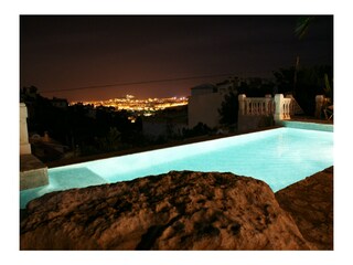 Pool bei Nacht mit Blick auf beleuchtete Stadt + Burg