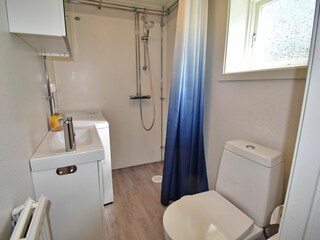 Badezimmer mit WC, Waschmaschine und Dusche