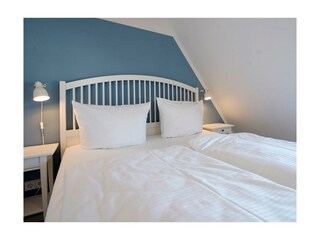 Stechelhus - Blick in ein Schlafzimmer mit Doppelbett und TV