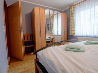 Schlafzimmer mit Doppelbett und Kleiderschrank
