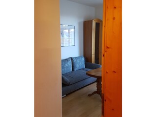 Wohnzimmer mit Schlafsofa und Schrankbett