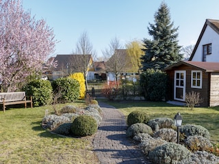 Sitzecke im Garten und Fahrradschuppen