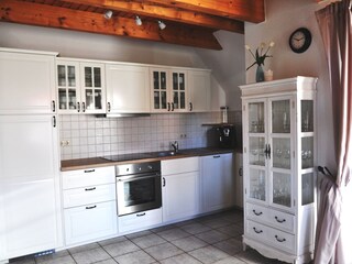 offene helle Landhausküche mit Zugang zur Terrasse