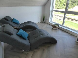 Galerie mit Relax-Sesseln und Ausblick