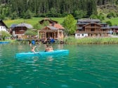 Blick vom See auf Steg, Badehaus und Haupthaus (rechts)