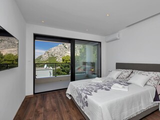 Das Schlafzimmer mit TV und Balkon