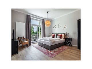 Schlafzimmer mit TV und Zugang zum Südbalkon