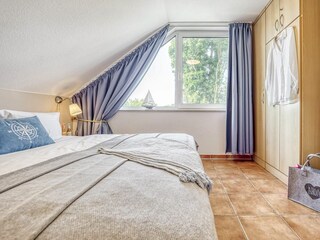 Schlafzimmer mit Doppelbett und Kleiderschrank