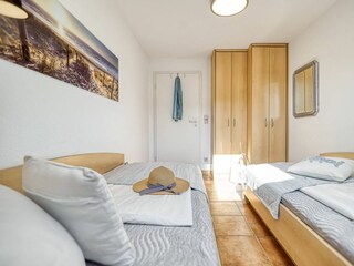 Schlafzimmer mit zwei Einzelbetten und Kleiderschrank