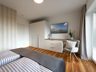 Schlafzimmer mit viel Stauraum und Flatscreen im EG