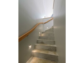 Die Treppe aus Beton und Handlauf aus Massivholz