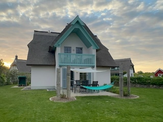 Garten mit großem Tisch und Sitzmöbeln und Strandkorb