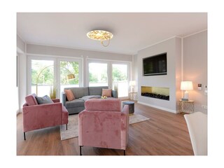 Strandvilla Gezeiten App. Goldrichtig-Wohnzimmer mit Elektrokamin