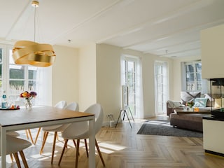 Blick auf Esstisch, Sofa und Kamin.