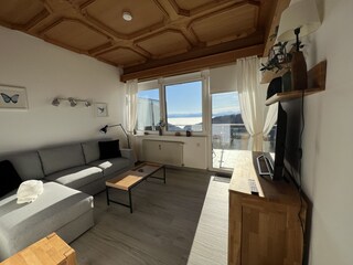 Wohnzimmer mit Schlafcouch und Blick auf den Balkon