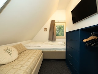 Das zweite Schlafzimmer mit Einzelbetten und 43"-TV