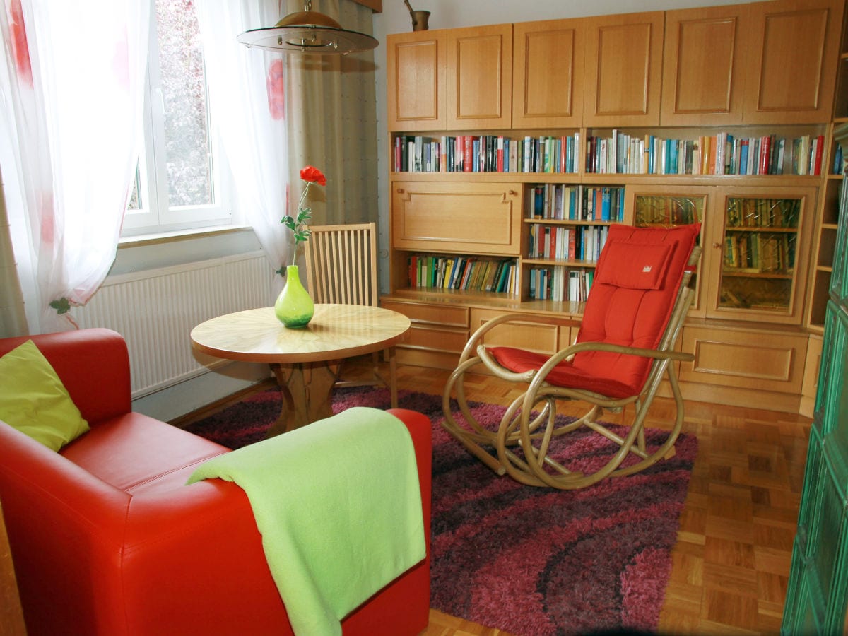 Wohnzimmer mit Schaukelstuhl und Bücherwand