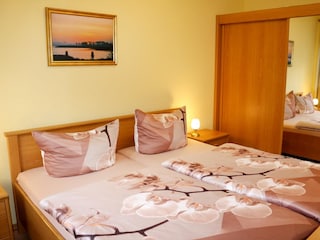 Schlafzimmer mit Doppelbett und Kleiderschrank