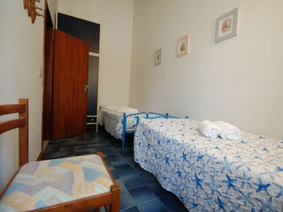 Schlafzimmer mit 2 Einzelbetten mit Blick auf den Pool