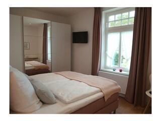 Schlafzimmer mit TV und kleinem Arbeitsplatz