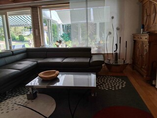 Wohnzimmer mit Blick in Wintergarten & Garten