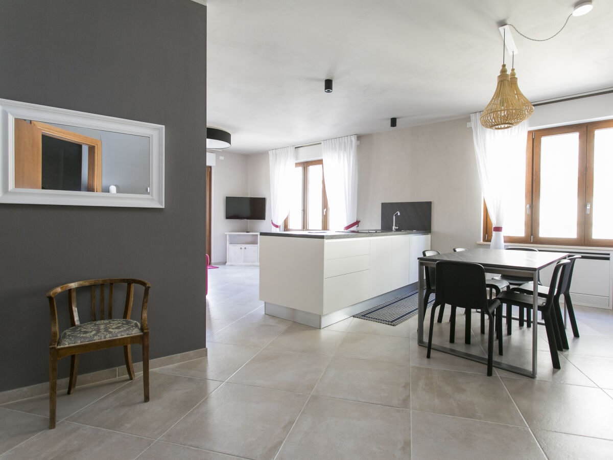 Spacious living room with kitchen, dining table and sofa