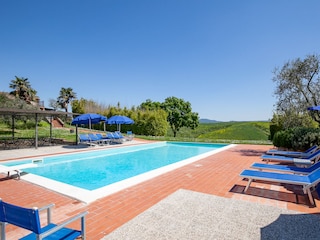 Poolbereich mit Liegen und Sonnenschirmen