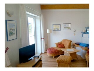 Wohnbereich mit Sofa, Sessel und TV