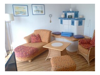 Wohnbereich mit Sofa, Sessel und Elektrokamin